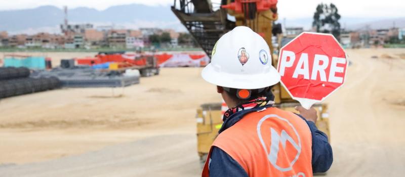 Trabajador con señal de PARE en uno de los frentes de obra del Metro de Bogotá