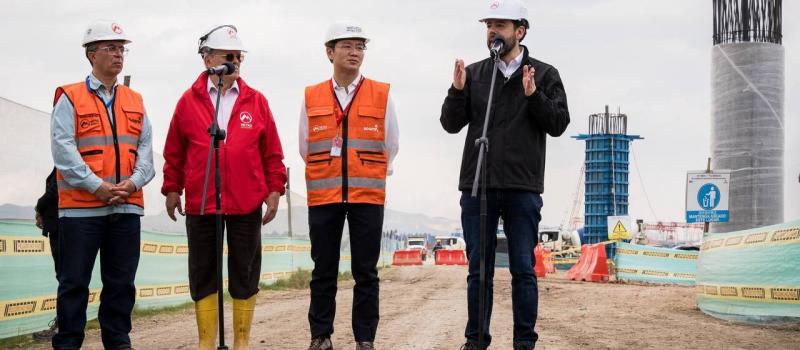 Alcalde Carlos Galán en el micrófono hablando desde el patio taller, junto al gerente del Metro, Wu Yu del concesionario Metro Línea 1 y Javier Descarga de la interventoría